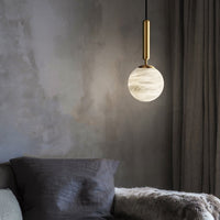 A modern natural marble Aelios chandelier, hanging in the living room above the sofa.