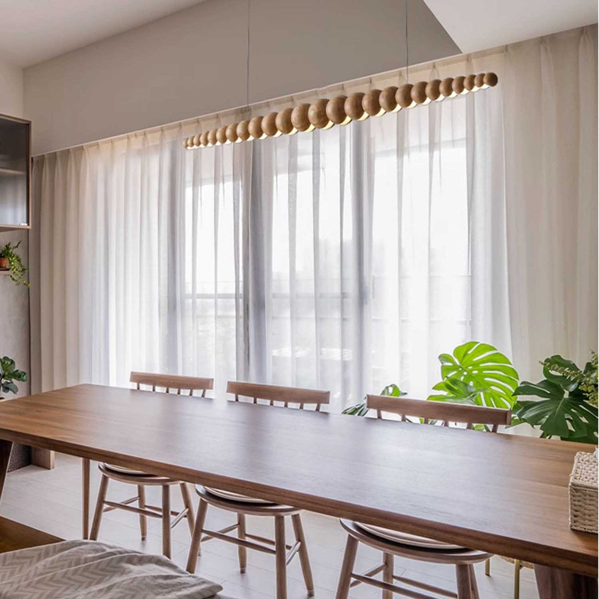 Side view of the Nimbus log wood chandelier above the dining table.